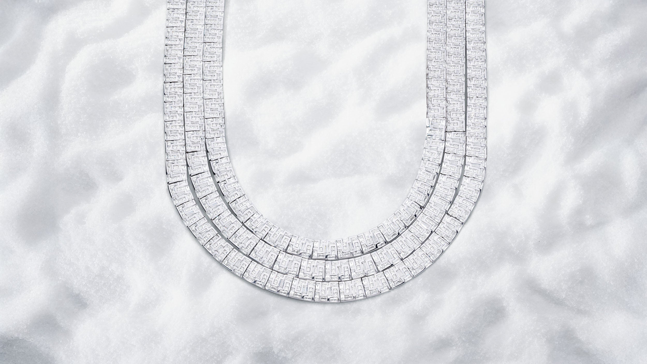 APM MONACO pave necklace in silver on a white snowy background