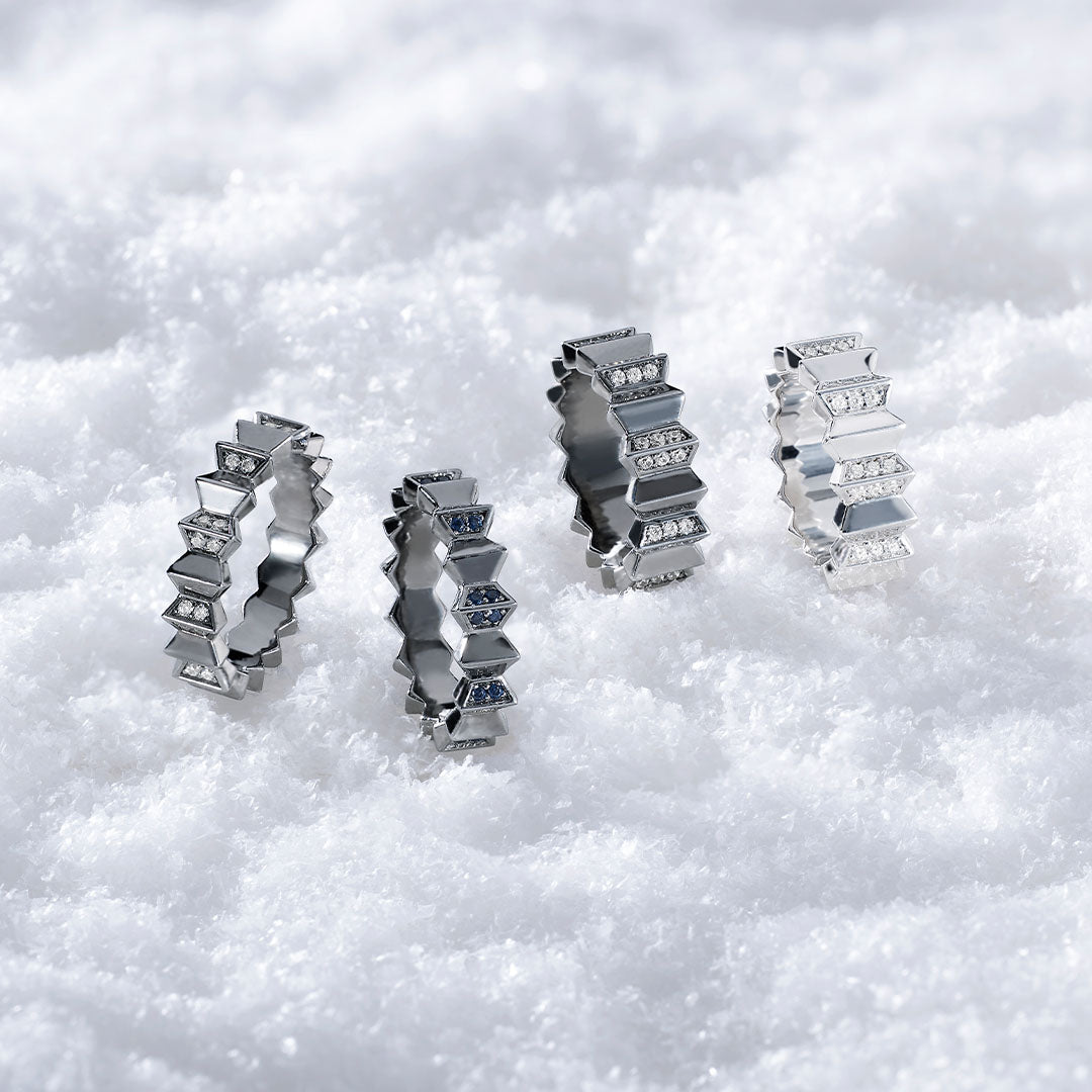 Four APM MONACO rings from up and down collection, on a white snowy background