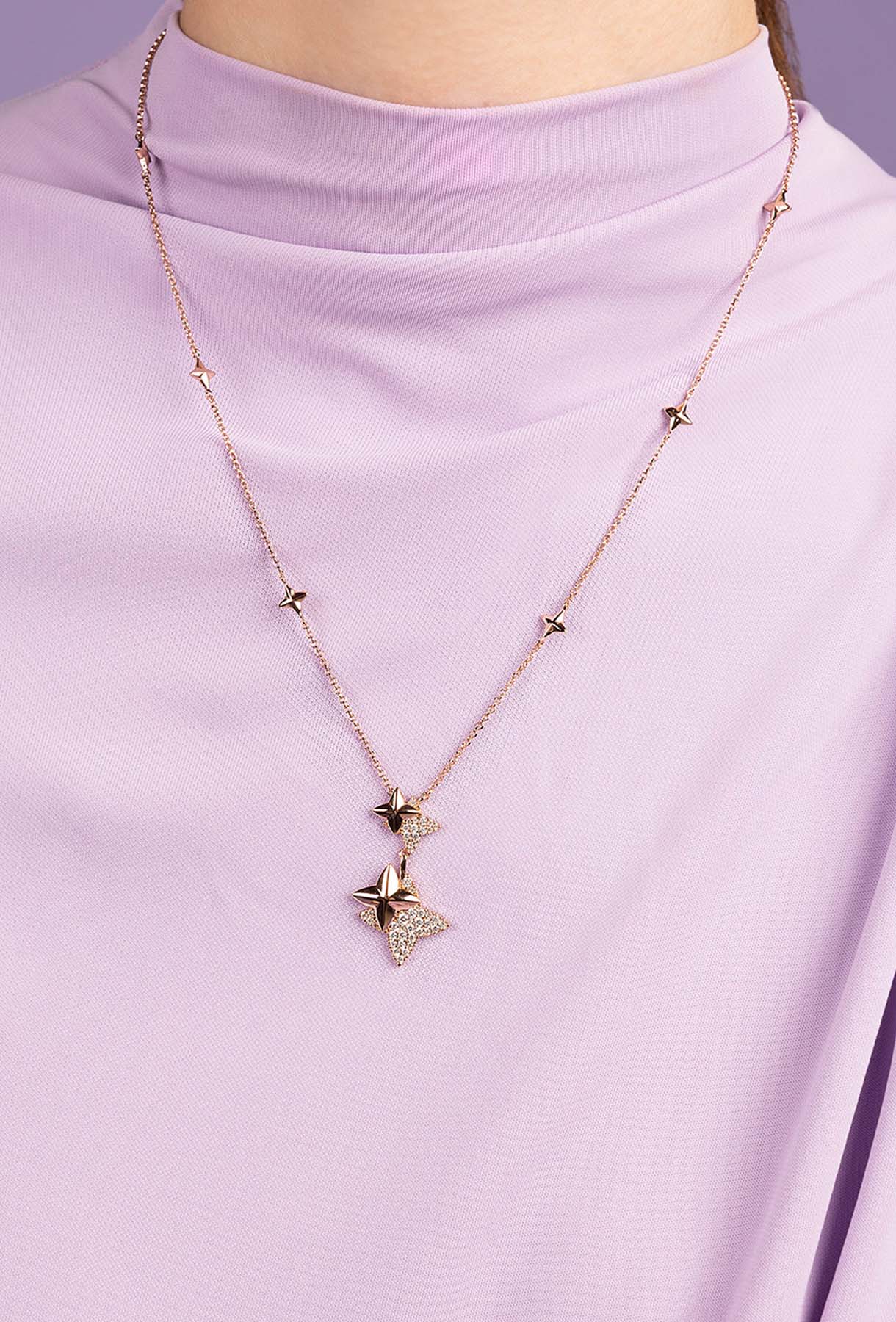 APM MOANCO necklace with rose gold star-shaped pendant on a person