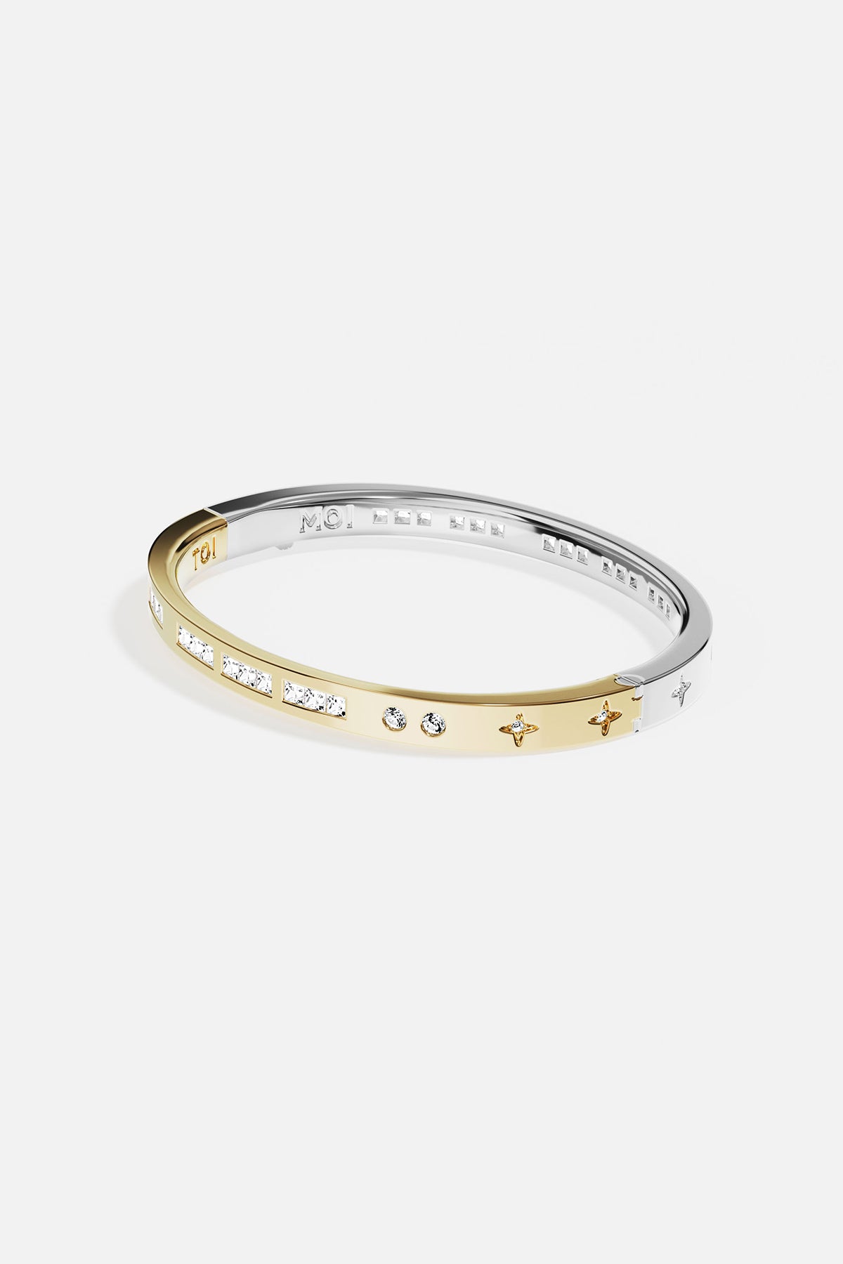 Gold and silver bangle with embedded stones on a white background