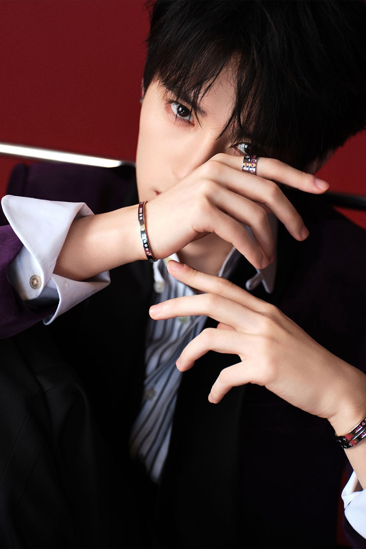 Model wearing bangles and rings with a dark background