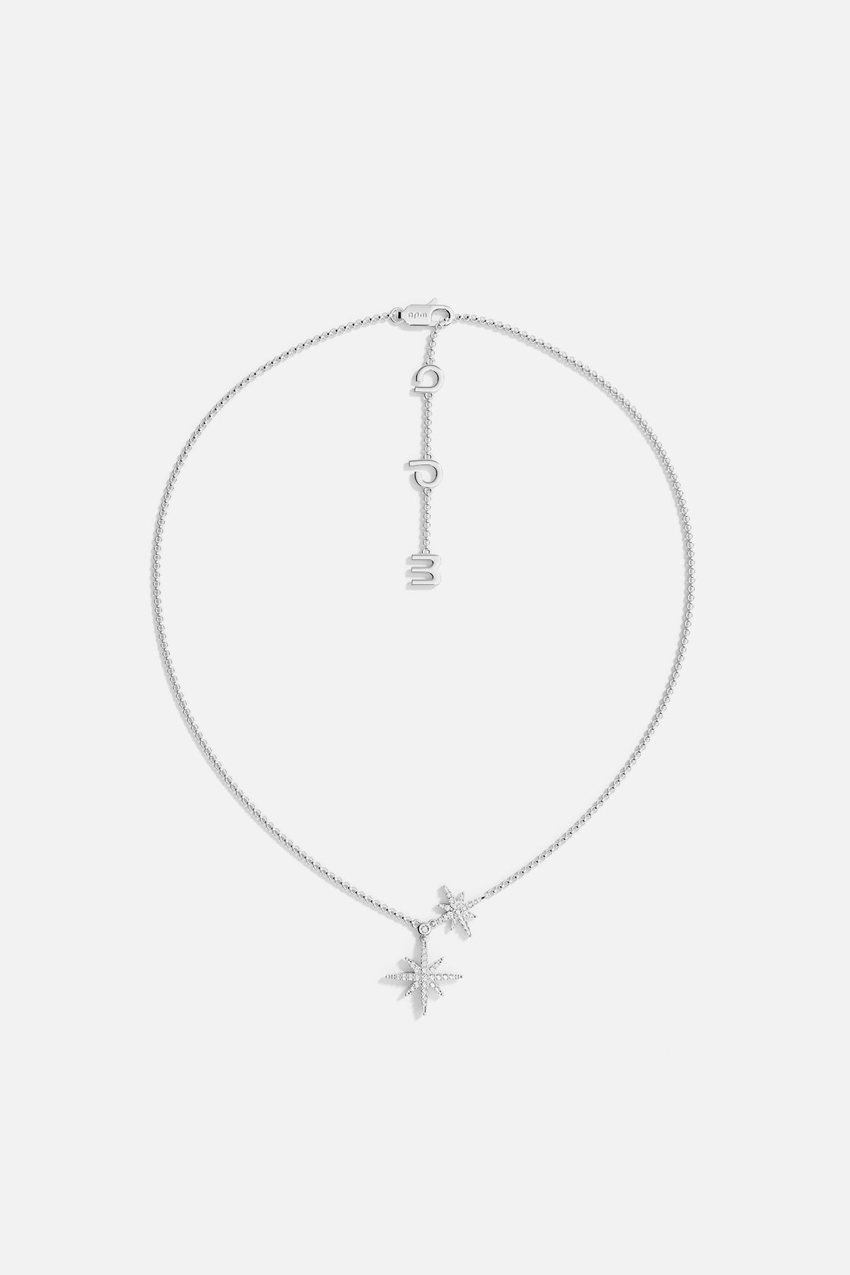 Silver necklace with star-shaped pendant on a light gray background