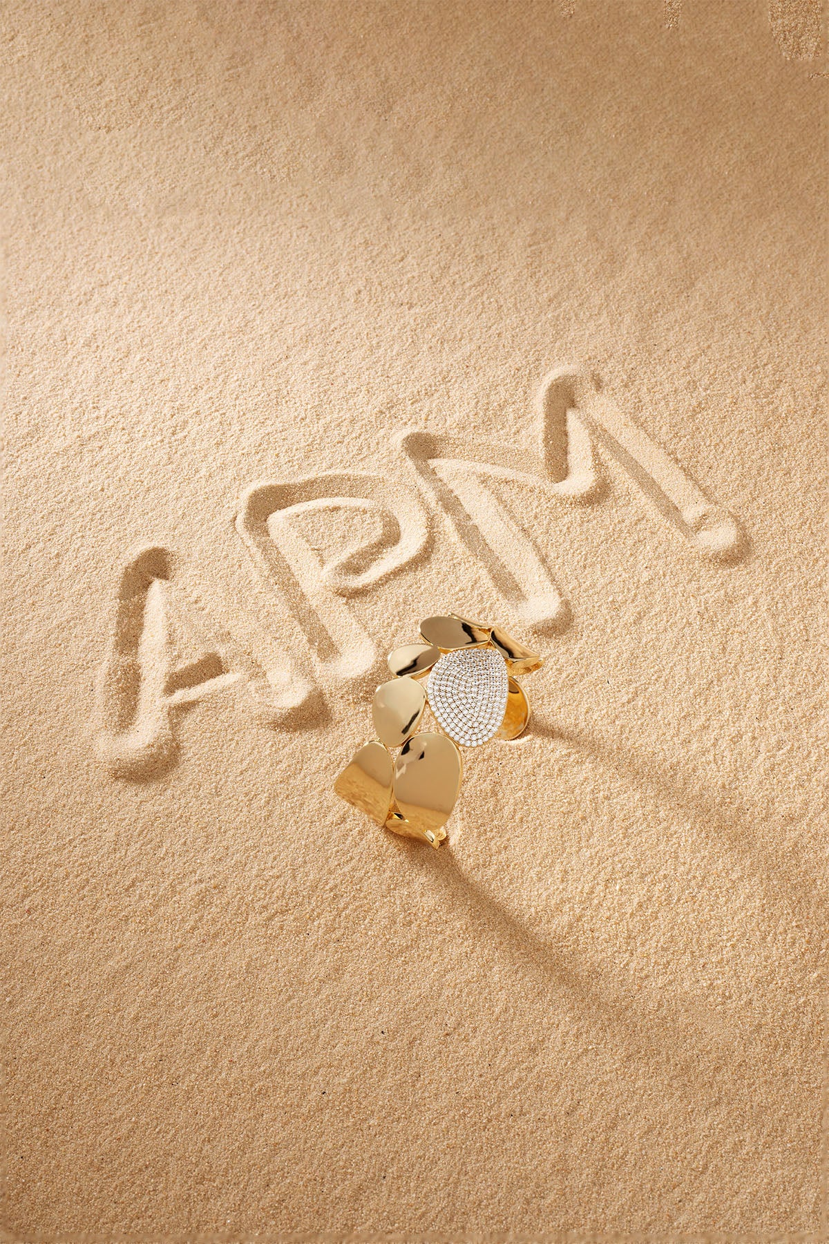 Bracelet APM Monaco, yellow gold with pavé diamonds at the center, statement galet bangle.